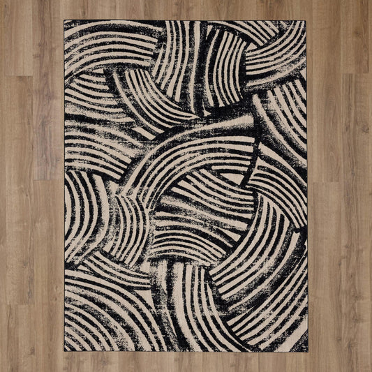 Karastan Alessio Arcoa Obsidian area rug featuring intricate patterns and a rich dark color in a spacious setting.